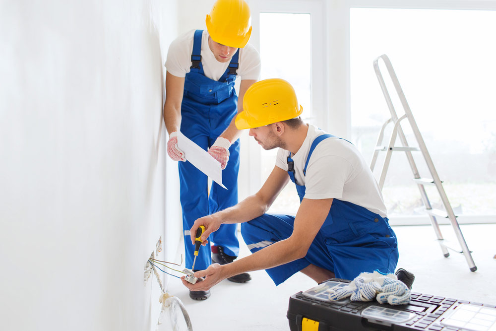 Two Electrician Workers Wiring Outlet